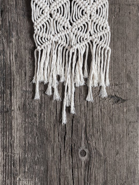 Macrame. Macrame weaving. White thread, wooden background, closeup
