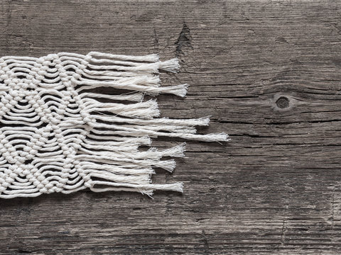 Macrame. Macrame weaving. White thread, wooden background, closeup