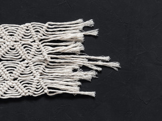 Macrame. Macrame weaving. White thread, black background, closeup