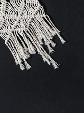 Macrame. Macrame weaving. White thread, black background, closeup