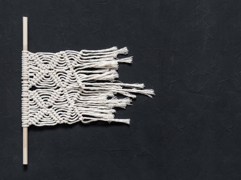Macrame. Macrame weaving. White thread, black background, closeup