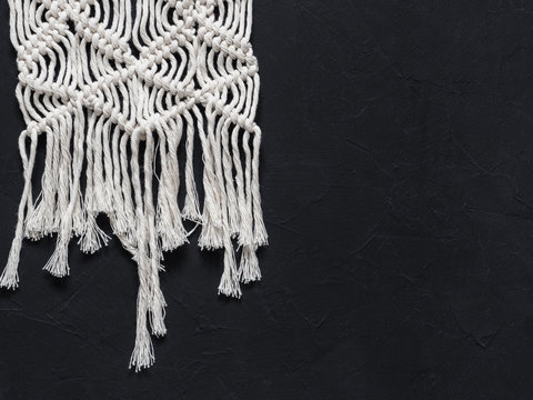 Macrame. Macrame weaving. White thread, black background, closeup