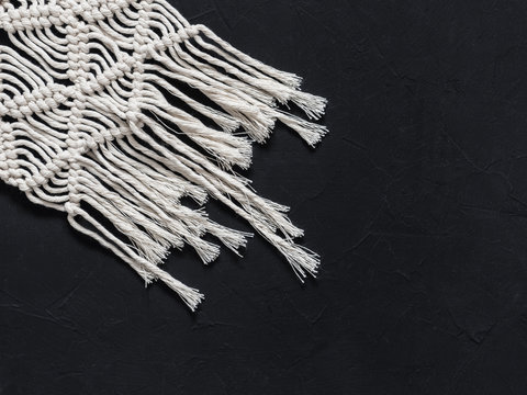 Macrame. Macrame weaving. White thread, black background, closeup