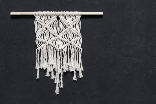 Macrame. Macrame weaving. White thread, black background, closeup