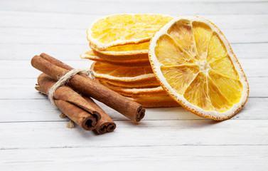 Orange slices with cinnamon on a light wooden background, enjoying the spices