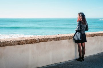 Woman looking at the sea from the promenade.