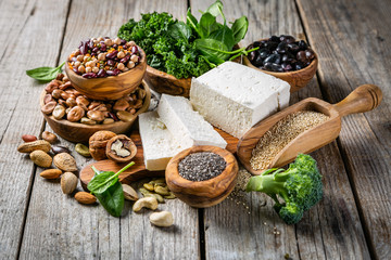 Selection of vegan plant protein sources - tofu, quinoa, spinach, broccoli, chia, nuts and seeds,...