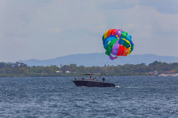 couple enjoy parasailing on a sunny vacation day on the tourist destination Mactan Island