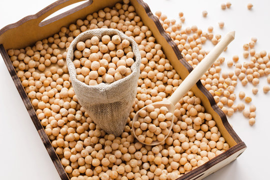 dry raw chickpeas in wooden box with spoon