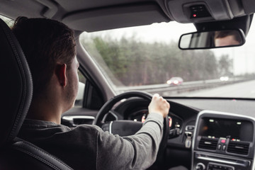 young man driving a car on the highway in Sweden.