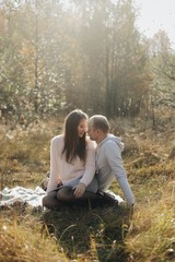 A beautiful woman in a dress sitting on the grass in the Park with a man.