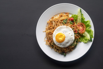 Asian dish fried noodles with egg and seafood or beef or chicken