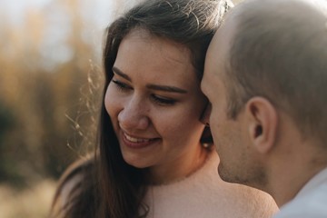 Naklejka premium Funny couple toghether with a smile. Happy young family in forest.