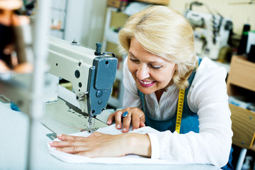 Mature woman sewing with professional machine