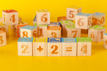 Colorful wooden blocks with letters on a yellow color background