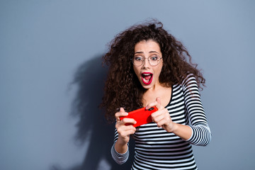 Closeup photo portrait of funny funky comic humorous screaming shouting student using telephone for playing games isolated grey background