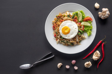 Asian dish fried noodles with egg and seafood or beef or chicken