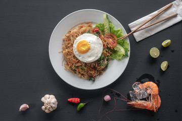 Asian dish fried noodles with egg and seafood or beef or chicken