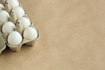 Cardboard egg rack with eggs on rustic background with copy space