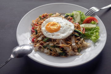 Asian dish fried noodles with egg and seafood or beef or chicken