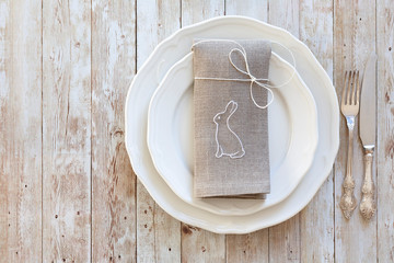 plate with a linen napkin on wooden table for Easter