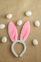 Top view of bunny ears easter holiday accessory and white egg on rustic background