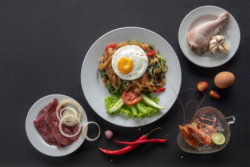 Asian dish fried noodles with egg and seafood or beef or chicken