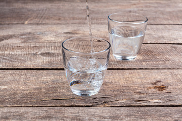 Glasses of water on a wooden table.