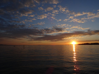 Blick von der Promenade auf den Sonnenuntergang über den Bodensee auf der Insel Lindau, Bayern, Deutschland