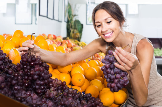  woman customer choosing grapes in fruit store