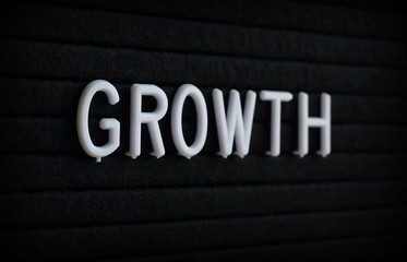 The word Growth in white plastic letters on a felt notice board