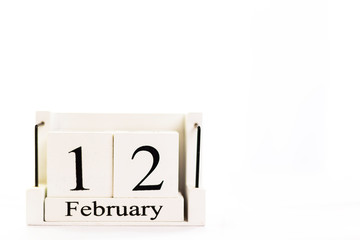 the day of February on a white clear background. a wooden desktop calendar that reminds us of what...