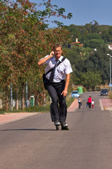 Fototapeta premium Young business man going to work with inline skate, alternative transport