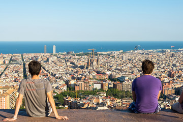 Fototapeta na wymiar Young people on top of the Park Guinardó are watching the skyline of Barcelona