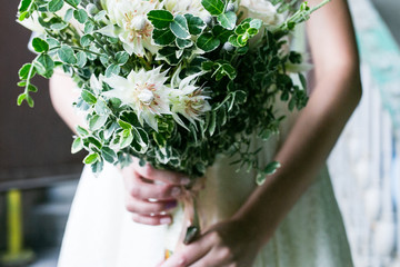 Beautiful rustic wedding bouquet in hands of the bride