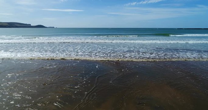 Woman on beach in New Zealand. Aerial drone footage of beach landscape at Te Waewae Bay beach by Orepuki in the Southland region of the south island of New Zealand.