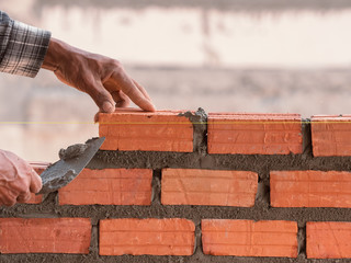 industrial bricklayer installing bricks on construction site