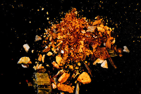 various spices scattered on a dark surface
