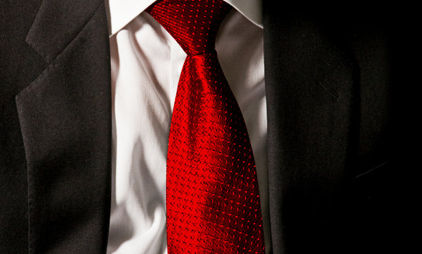 The Boss's Tie. The Businessman Is Wearing His Dark Gray Jacket On The White Shirt With A Gaudy Red Tie