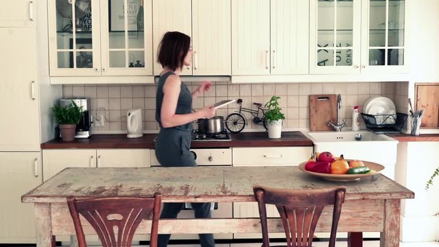 Woman cooking and checking recipe on tablet in the kitchen 
