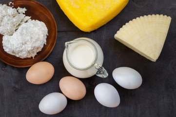 Farm products. Eggs, cheese, cottage, milk on dark background. Top view.