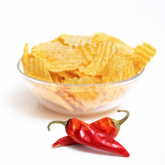 Fototapeta na wymiar Bowl of potato chips with red hot pepper on white background