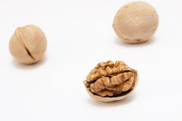 Walnuts, whole and opened, on white background. Top views of nuts and kernel halves.