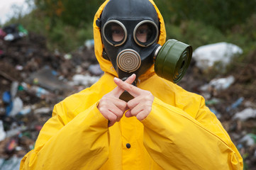 Environmental pollution. Man in gas mask shows crossed fingers.