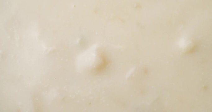 Top close video of stirring canned clam chowder with a spoon then taking a spoonful at the end.