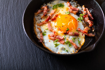 Food concept Fried egg and cheese bacon in cast iron skillet with copy space