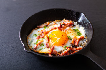 Food concept Fried egg and cheese bacon in cast iron skillet with copy space
