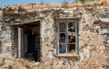 Fototapeta na wymiar Woman standing in ruins of abandoned house
