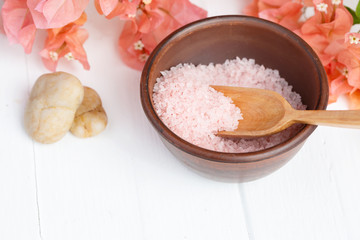 Himalayan pink spa salt in a clay bowl on a white background. Massage, aromatherapy.
