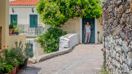 Fototapeta na wymiar Woman walking through streets of Greek Village